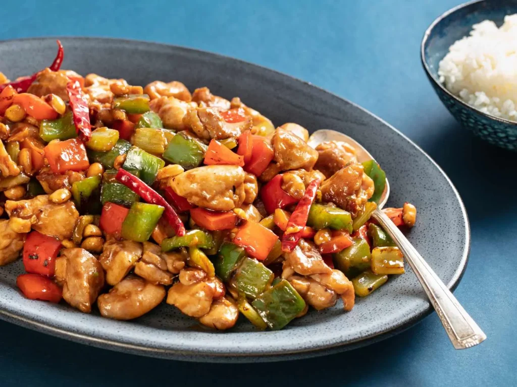 A plate of Kung Pao chicken with diced chicken recipes, peppers, and peanuts, showcasing a delicious Diced Chicken Recipe.
