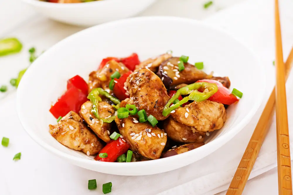 A delicious plate of chicken and shrimp stir fry garnished with vegetables