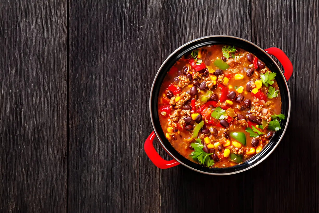 A hearty bowl of Ground Beef Stew with beans, corn, and peppers, garnished with fresh cilantro.