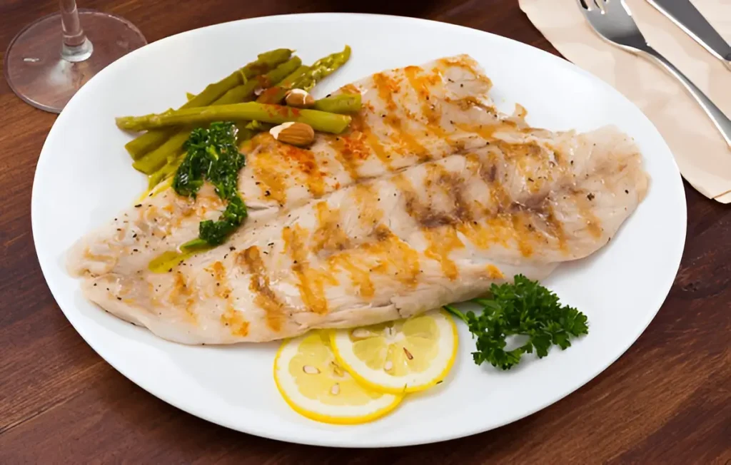 Grilled rockfish served with asparagus and lemon slices. Rockfish Recipes.