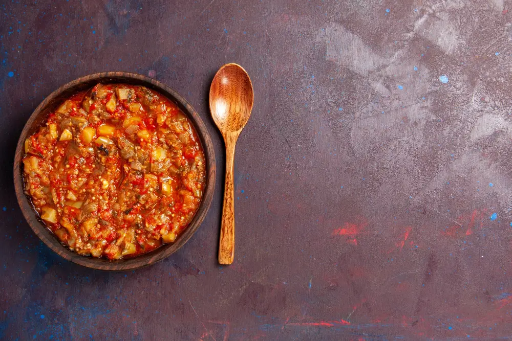 A bowl of hearty Turkey Chili Recipe with a wooden spoon on a rustic background.